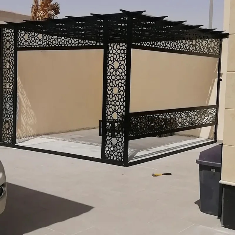 برجولة معدنية سوداء بأعمدة مكسوة بألواح ليزر مفرغة بنقوش هندسية