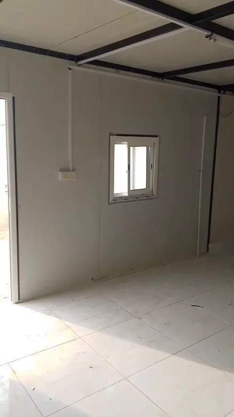 غرفة داخلية بجدران ساندوتش بانل بيضاء ونافذة صغيرة بعد اكتمال التركيب