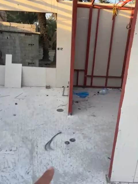 هيكل معدني مدهون بالأحمر قيد التركيب قبل تثبيت ألواح الساندوتش بانل