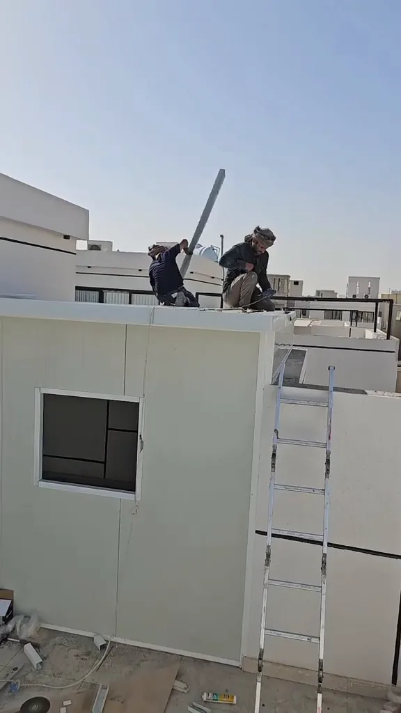 منظر قريب لحافة سقف ساندوتش بانل يوضح طريقة إنهاء الحافة فوق الجدار
