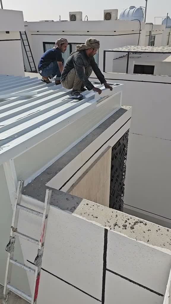 عاملان يثبتان ألواح السقف ويضبطان محاذاتها قبل ربطها ببعضها.