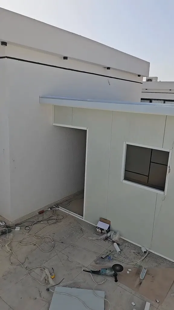 غرفة ساندوتش بانل بيضاء بنافذة بعد اكتمال تركيب ألواح السقف والجدران