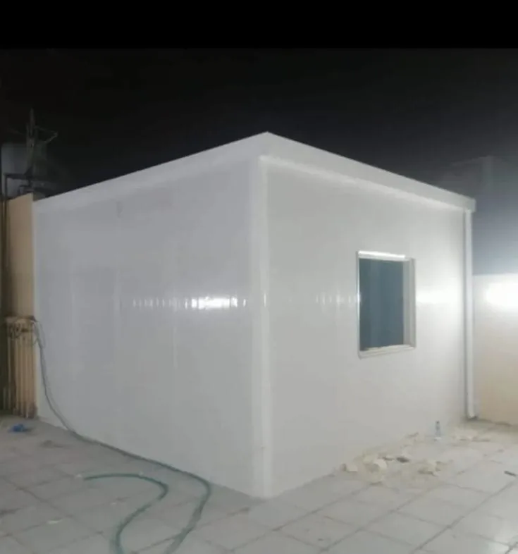 الجدران الداخلية البيضاء لغرفة ساندوتش بانل بعد اكتمال التركيب مع نافذة صغيرة