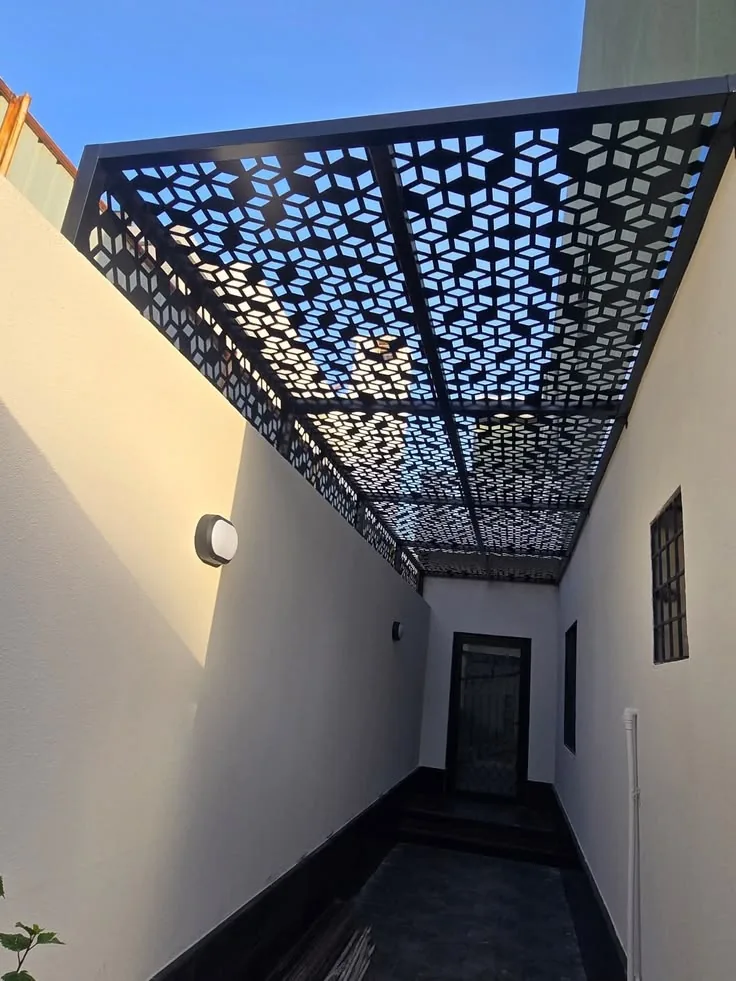 مظلة ممر ضيق بألواح ليزر مفرغة سوداء بين جدارين
